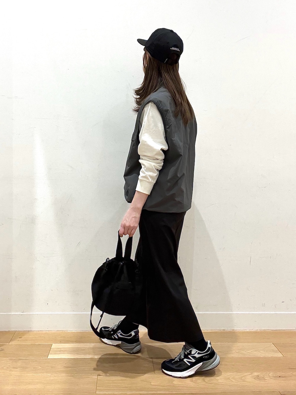 ブラック系のショルダーバッグ、ブラック系のスカート、グレー系のナイロンジャケットを着用したレディースの冬コーディネートの3枚目の写真