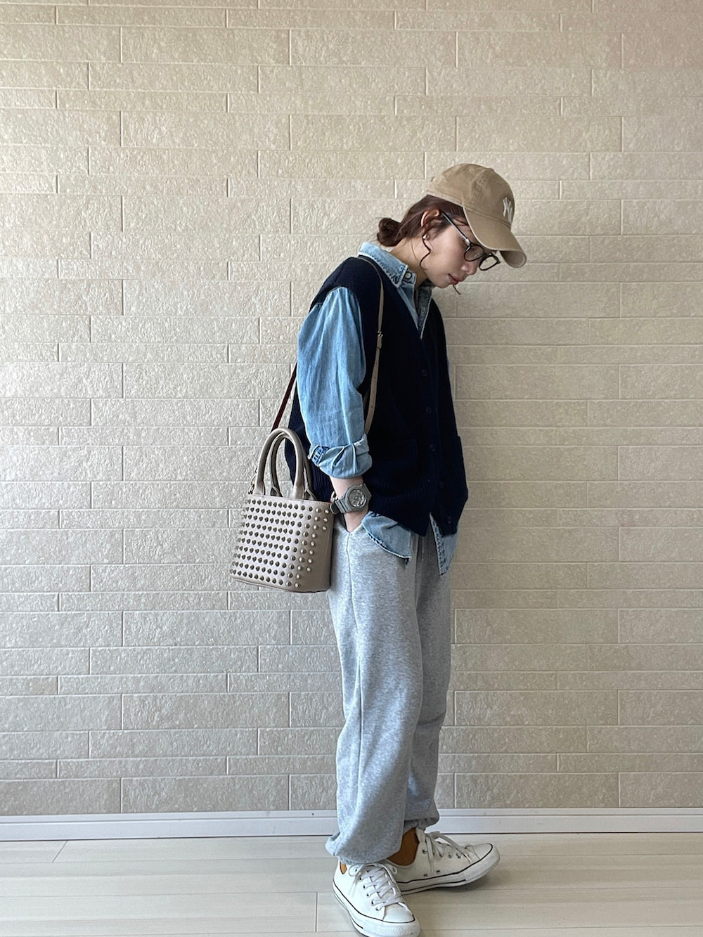 ベージュ系のトートバッグ、ブルー系のベスト、ブルー系のシャツ/ブラウスを着用したレディースの春コーディネートの2枚目の写真