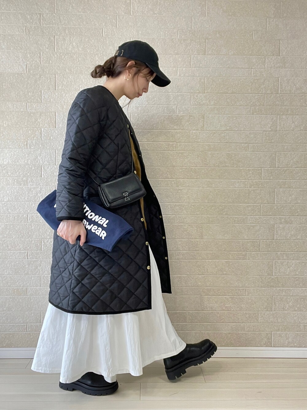 ブラック系のその他アウター、ブルー系のトートバッグ、ブラウン系のベストを着用したレディースの冬コーディネートの3枚目の写真