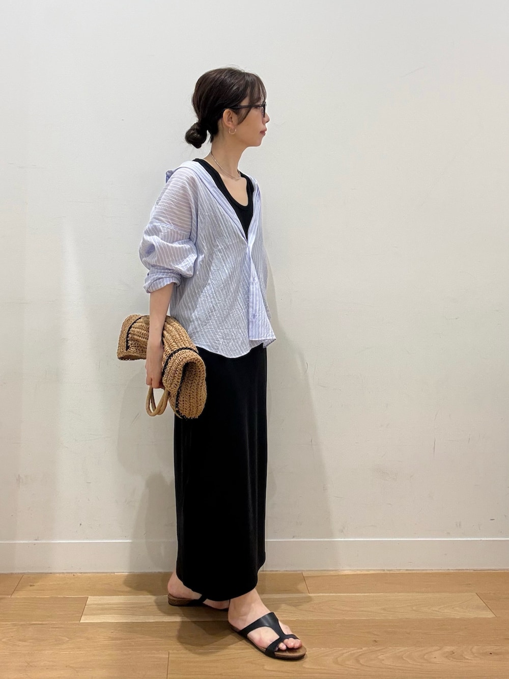 ベージュ系のトートバッグ、ブラック系のサンダル、ブラック系のワンピースを着用したレディースの夏コーディネートの3枚目の写真