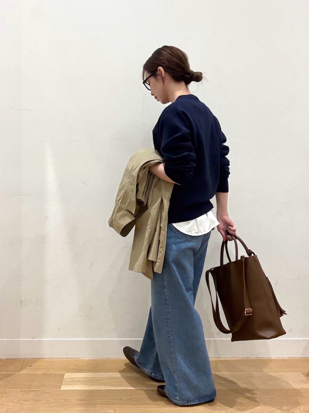 ブルー系のニット/セーター、ホワイト系のTシャツ/カットソー、ブラウン系のトートバッグを着用したレディースの冬コーディネートの5枚目の写真