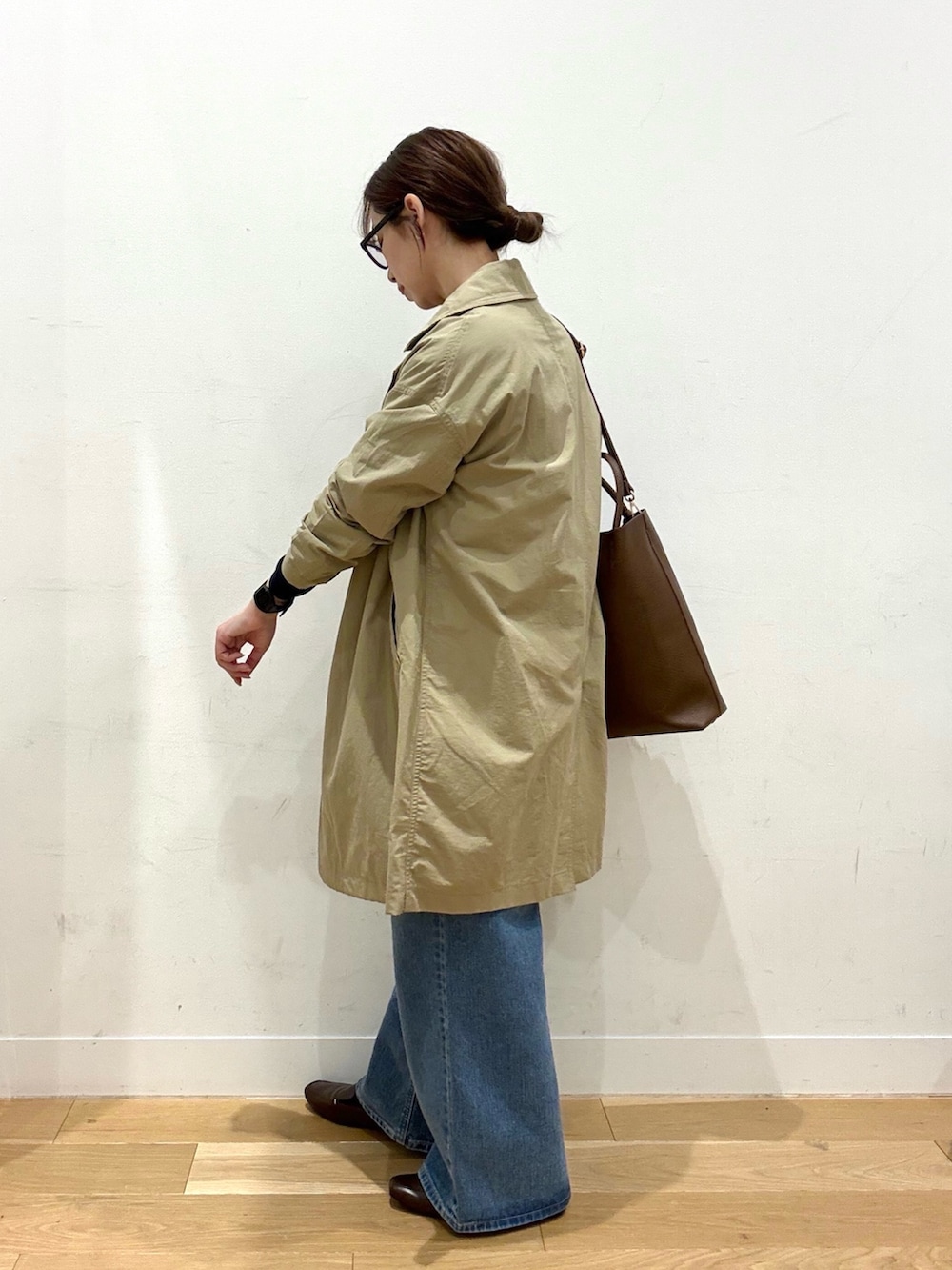 ブルー系のニット/セーター、ホワイト系のTシャツ/カットソー、ブラウン系のトートバッグを着用したレディースの冬コーディネートの2枚目の写真