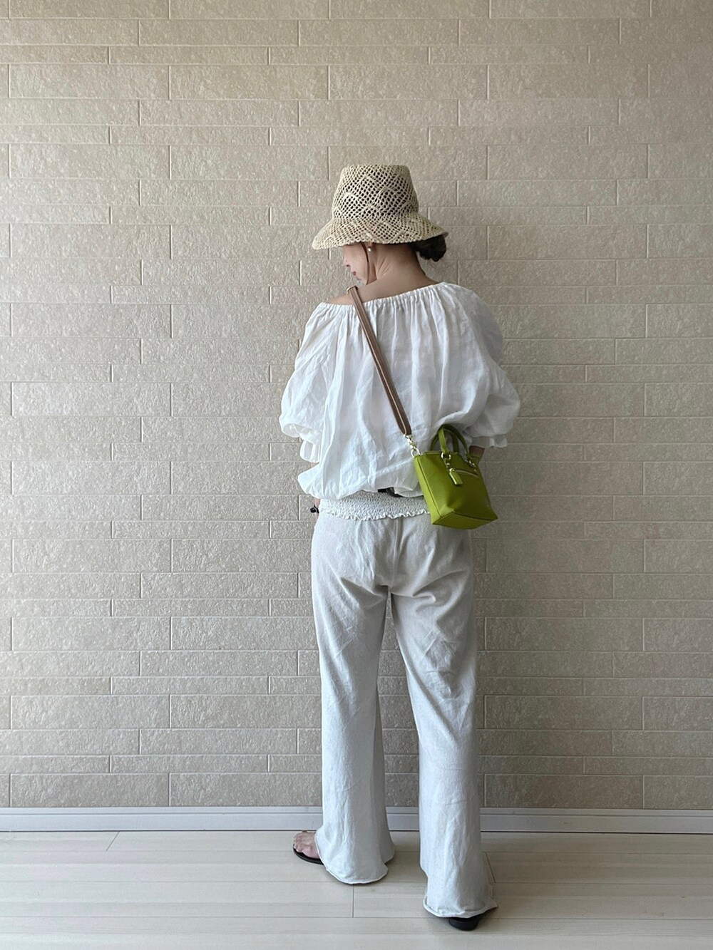 グリーン系のショルダーバッグ、ホワイト系のシャツ/ブラウス、ホワイト系のスニーカーを着用したレディースの夏コーディネートの4枚目の写真
