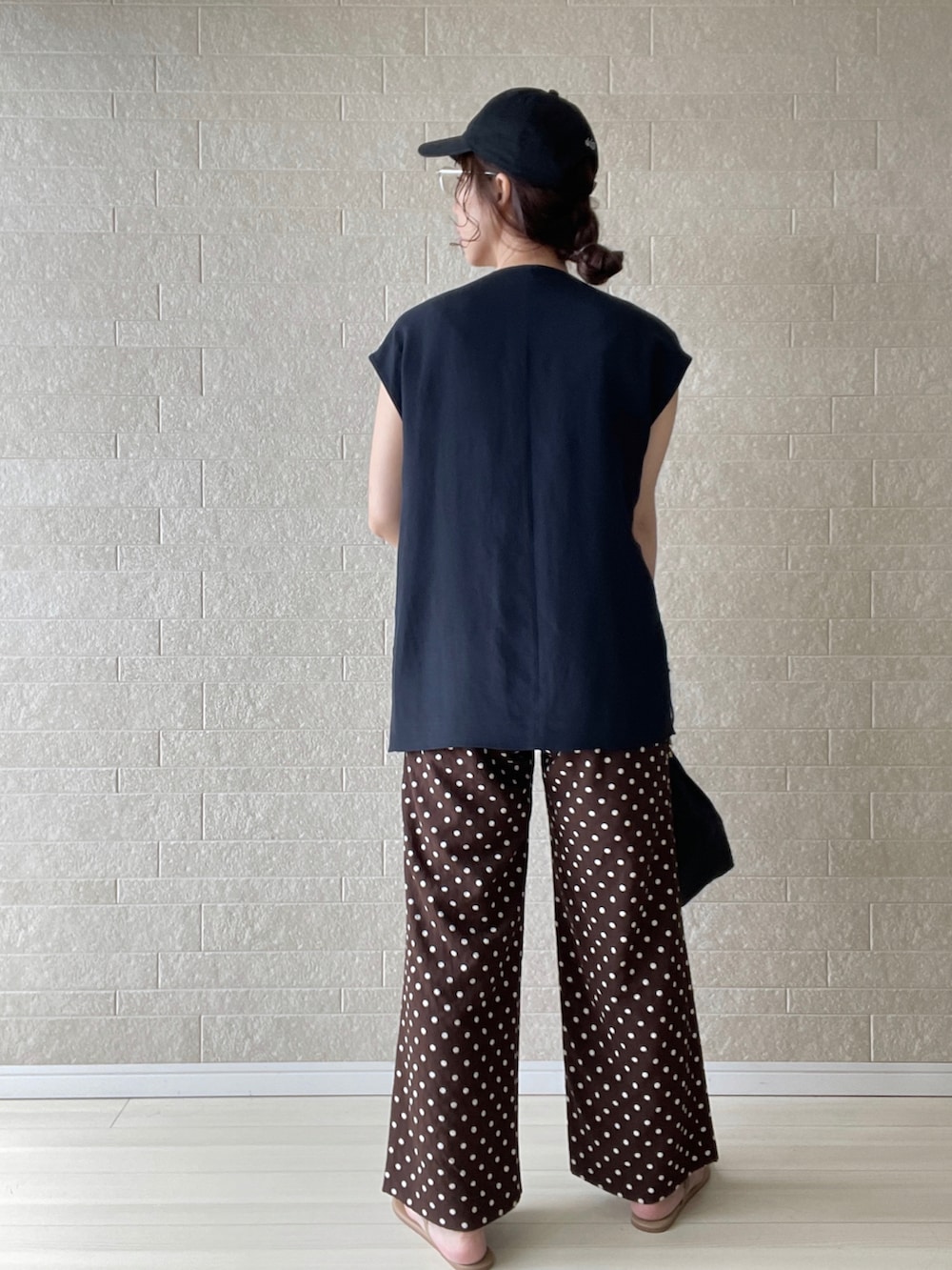 ブラウン系のその他パンツ、ブラック系のベスト、ブラウン系のサンダルを着用したレディースの夏コーディネートの4枚目の写真