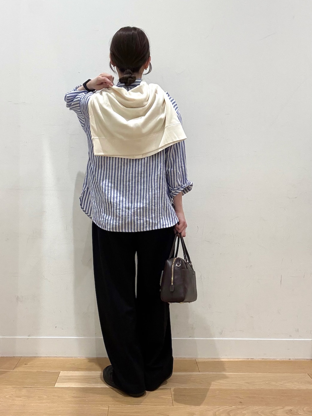 ホワイト系のブルゾン、ブラウン系のボストンバッグ、ブラック系のその他パンツを着用したレディースの春コーディネートの3枚目の写真