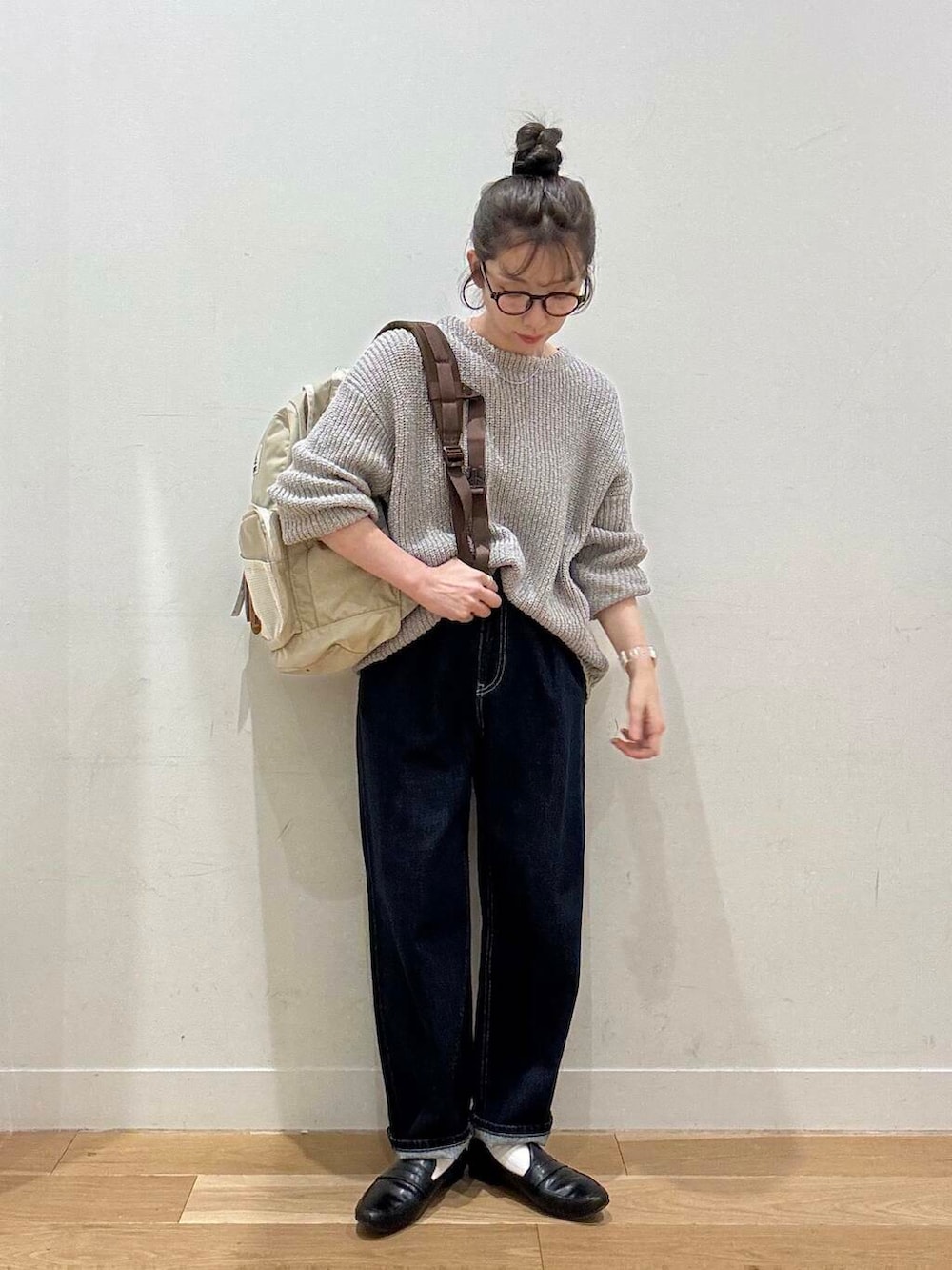 ブラック系のローファー、ブルー系のデニムパンツ、グレー系のニット/セーターを着用したレディースの春コーディネートの8枚目の写真