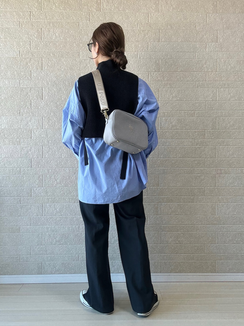 グレー系のショルダーバッグ、グレー系のその他パンツ、ブラック系のベストを着用したレディースの秋コーディネートの2枚目の写真