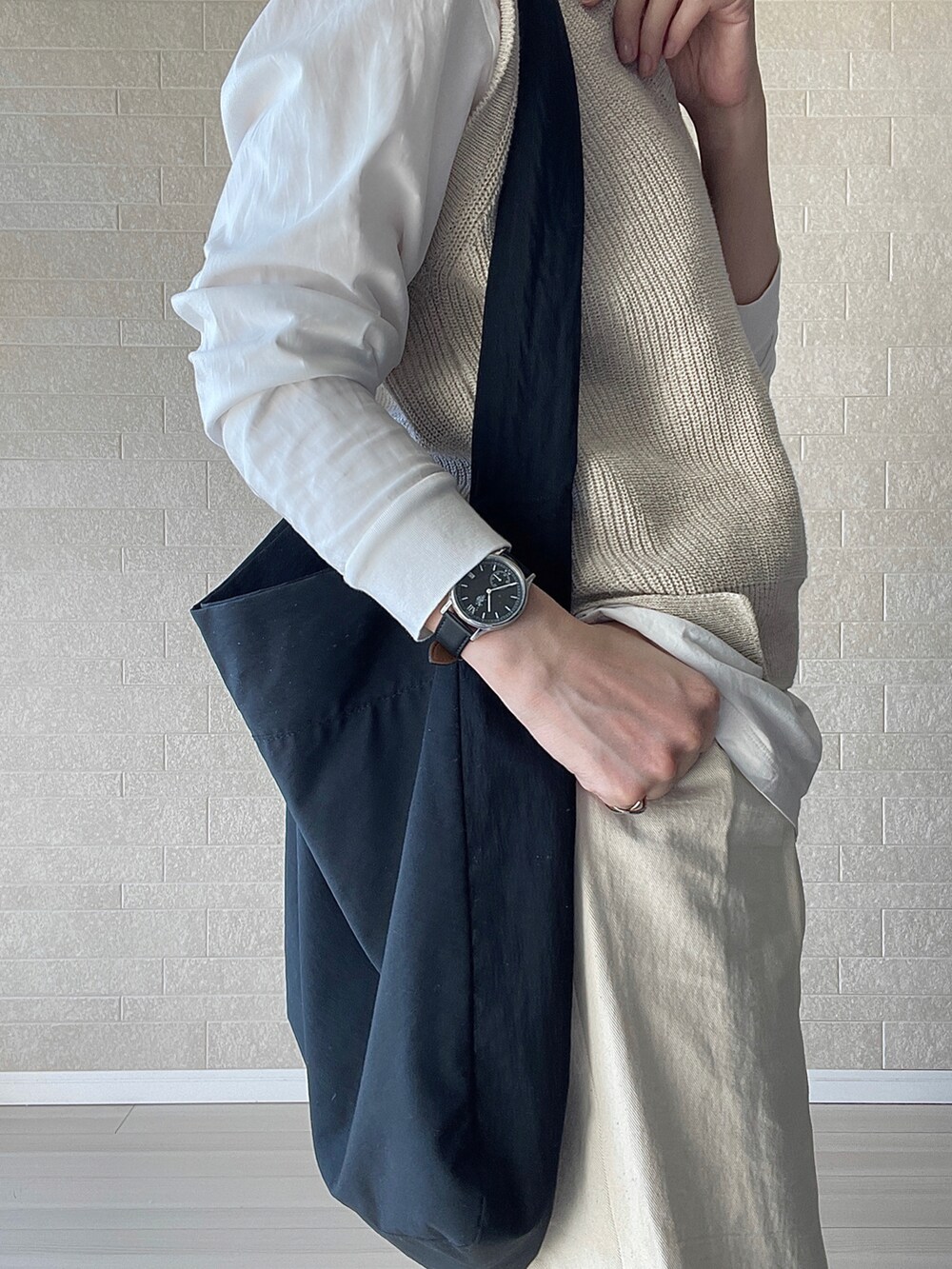 ホワイト系のその他パンツ、ブラック系のショルダーバッグ、ベージュ系のベストを着用したレディースの冬コーディネートの5枚目の写真