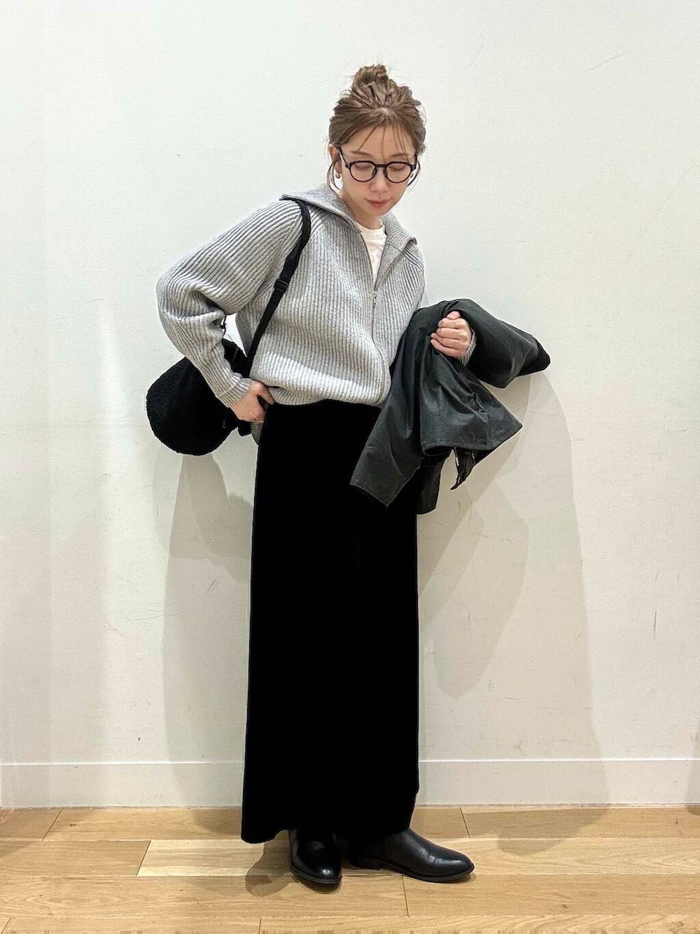 ブラック系のブーツ、グレー系のカーディガン/ボレロ、ブラック系のスカートを着用したレディースの冬コーディネートの4枚目の写真