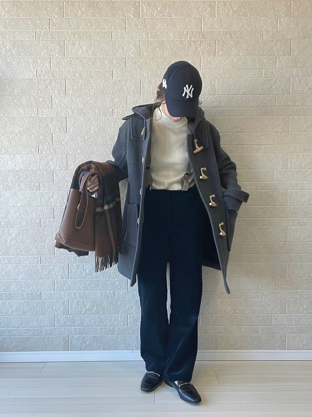 ホワイト系のニット/セーター、ブラック系のローファー、グレー系のダッフルコートを着用したレディースの冬コーディネートの2枚目の写真