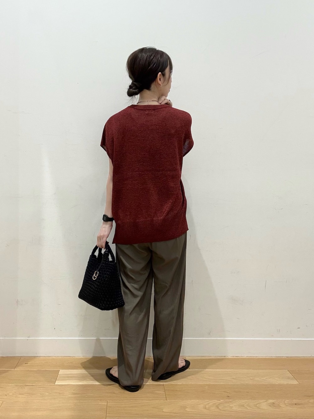 ブラック系のハンドバッグ、レッド系のその他トップス、ブラウン系のその他パンツを着用したレディースの夏コーディネートの2枚目の写真