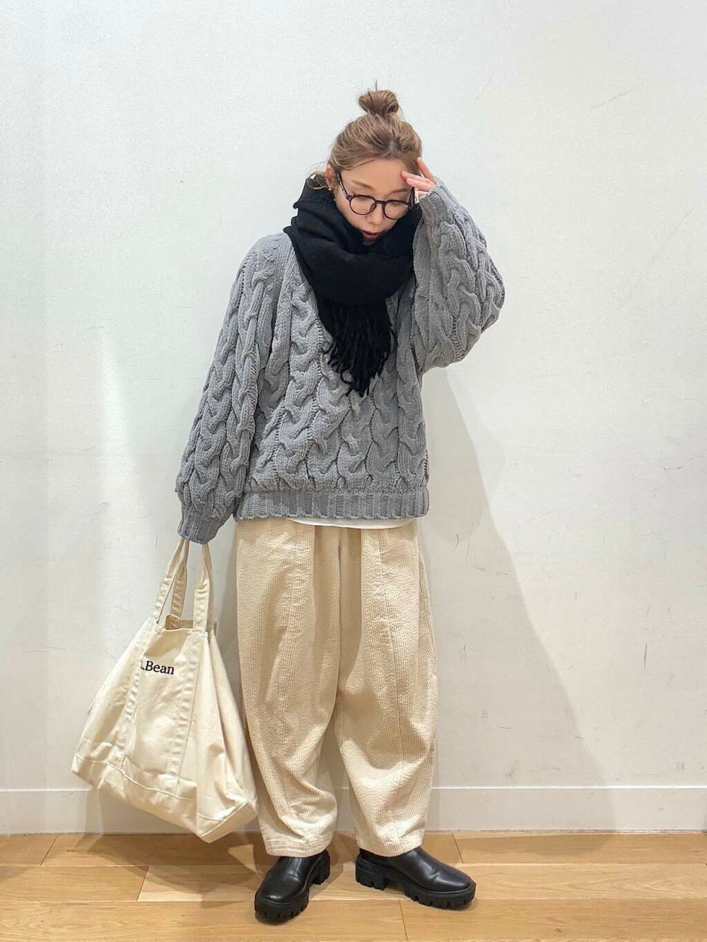 ホワイト系のトートバッグ、ブラック系のブーツ、ホワイト系のTシャツ/カットソーを着用したレディースの冬コーディネートの2枚目の写真