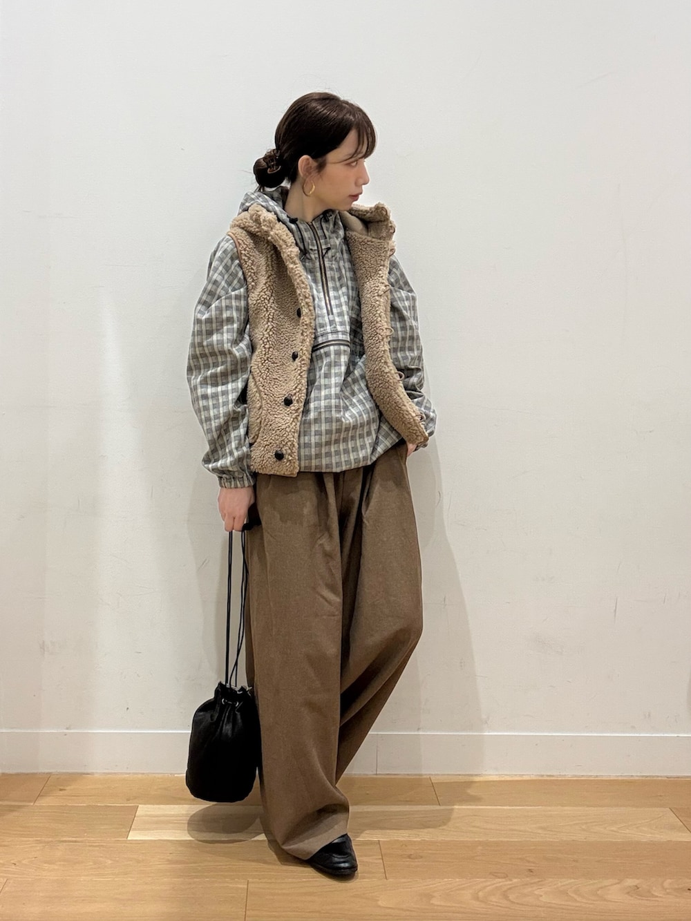 ベージュ系のダウンベスト、レッド系のTシャツ/カットソー、ブラック系のローファーを着用したレディースの秋コーディネートの3枚目の写真