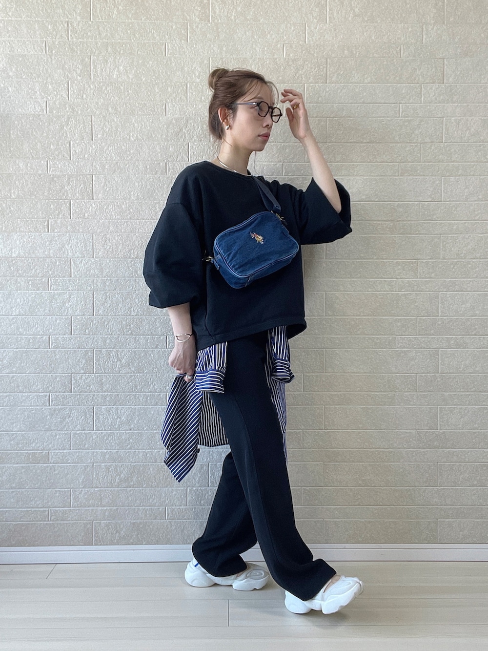 ブルー系のショルダーバッグ、ブラック系のその他パンツ、ホワイト系のサンダルを着用したレディースの春コーディネートの2枚目の写真