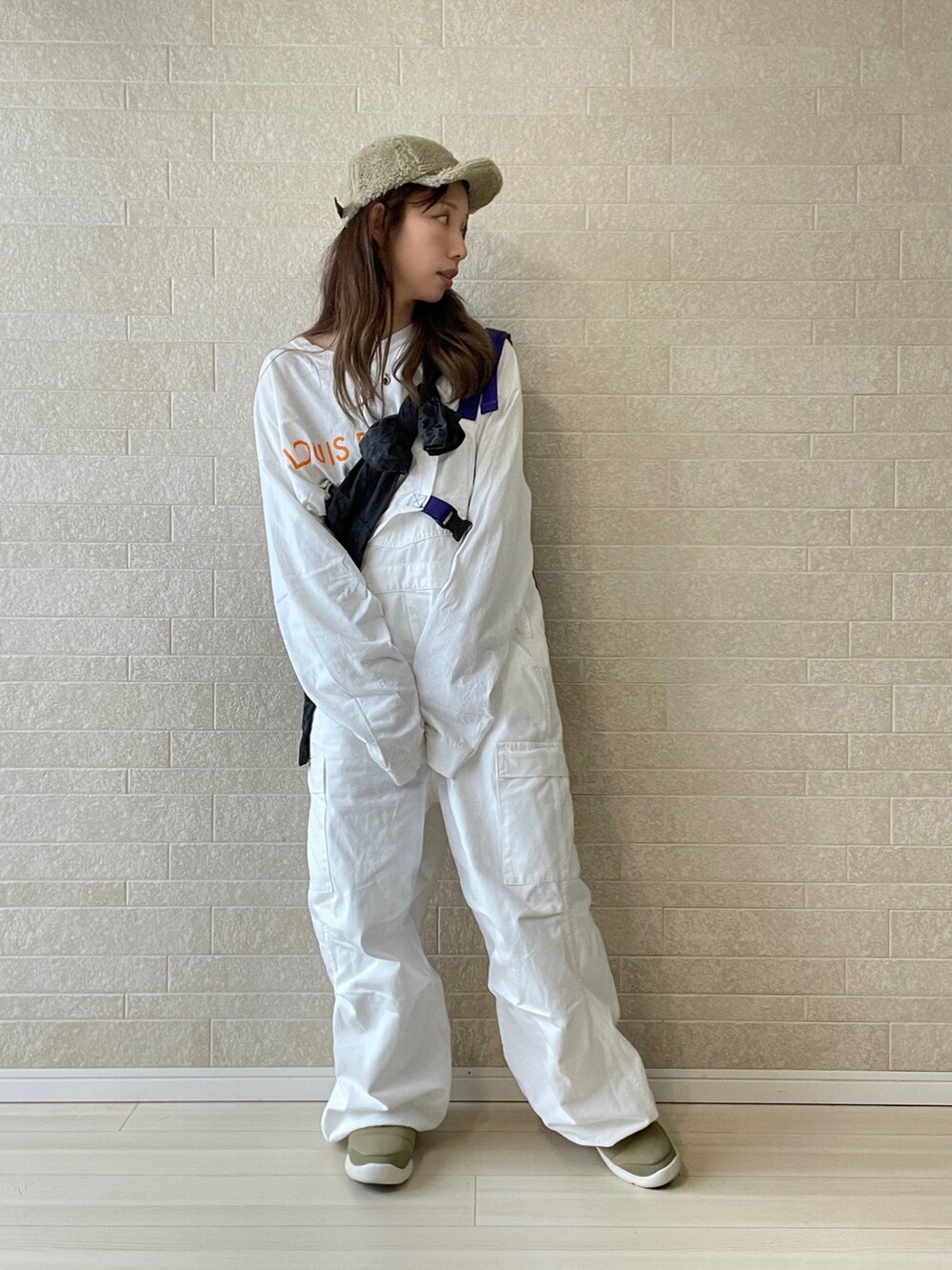 ホワイト系のサロペット/オーバーオール、ベージュ系のスニーカー、ブラック系のジャケット/アウターを着用したレディースの秋コーディネートの3枚目の写真