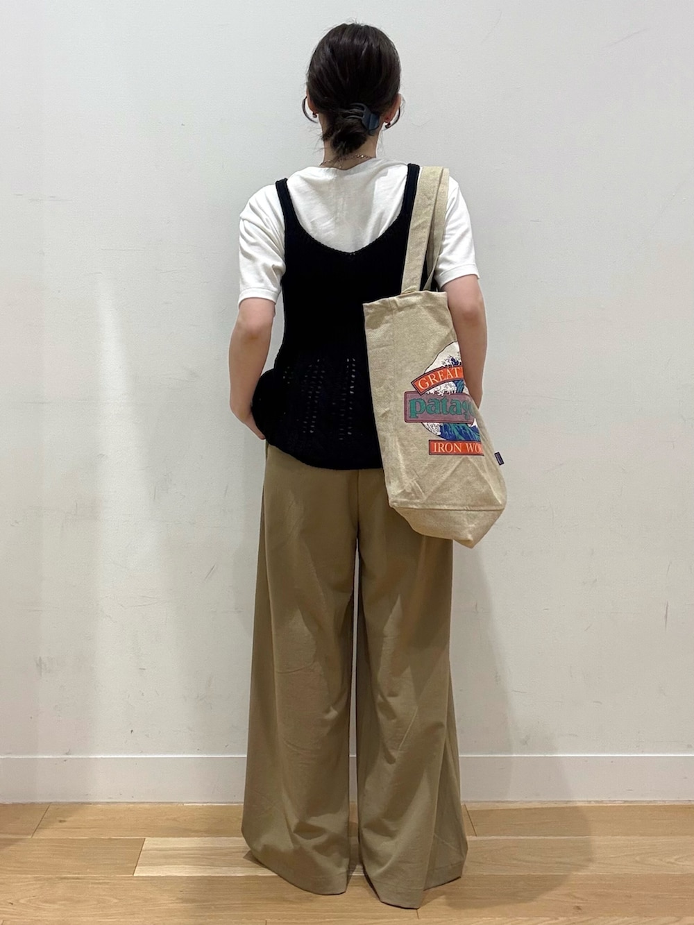 レッド系のスニーカー、ベージュ系のその他パンツ、ブラウン系のトートバッグを着用したレディースの夏コーディネートの2枚目の写真