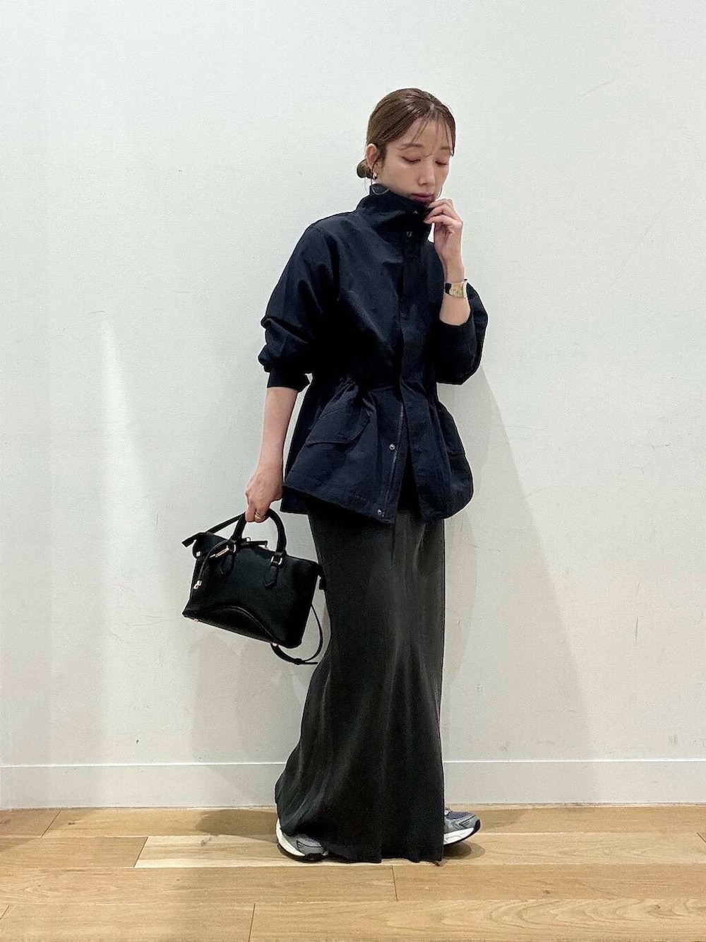 ブラウン系のタンクトップ、グレー系のスカート、ブラック系のボストンバッグを着用したレディースの秋コーディネートの2枚目の写真