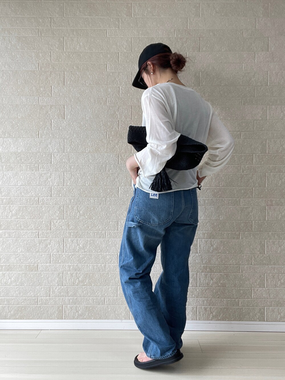 ブルー系のデニムパンツ、ホワイト系のTシャツ/カットソー、ブラック系のサンダルを着用したレディースの春コーディネートの4枚目の写真