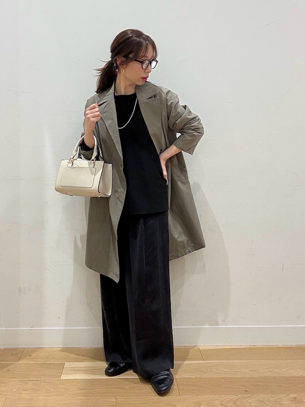 ホワイト系のハンドバッグ、ブラウン系のその他アウター、ブラック系のニット/セーターを着用したレディースの冬コーディネートの2枚目の写真