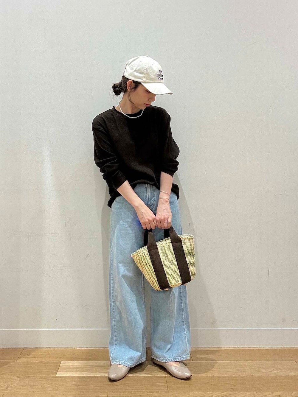 ホワイト系のハンドバッグ、グレー系のパンプス、ブラウン系のTシャツ/カットソーを着用したレディースの春コーディネートの2枚目の写真