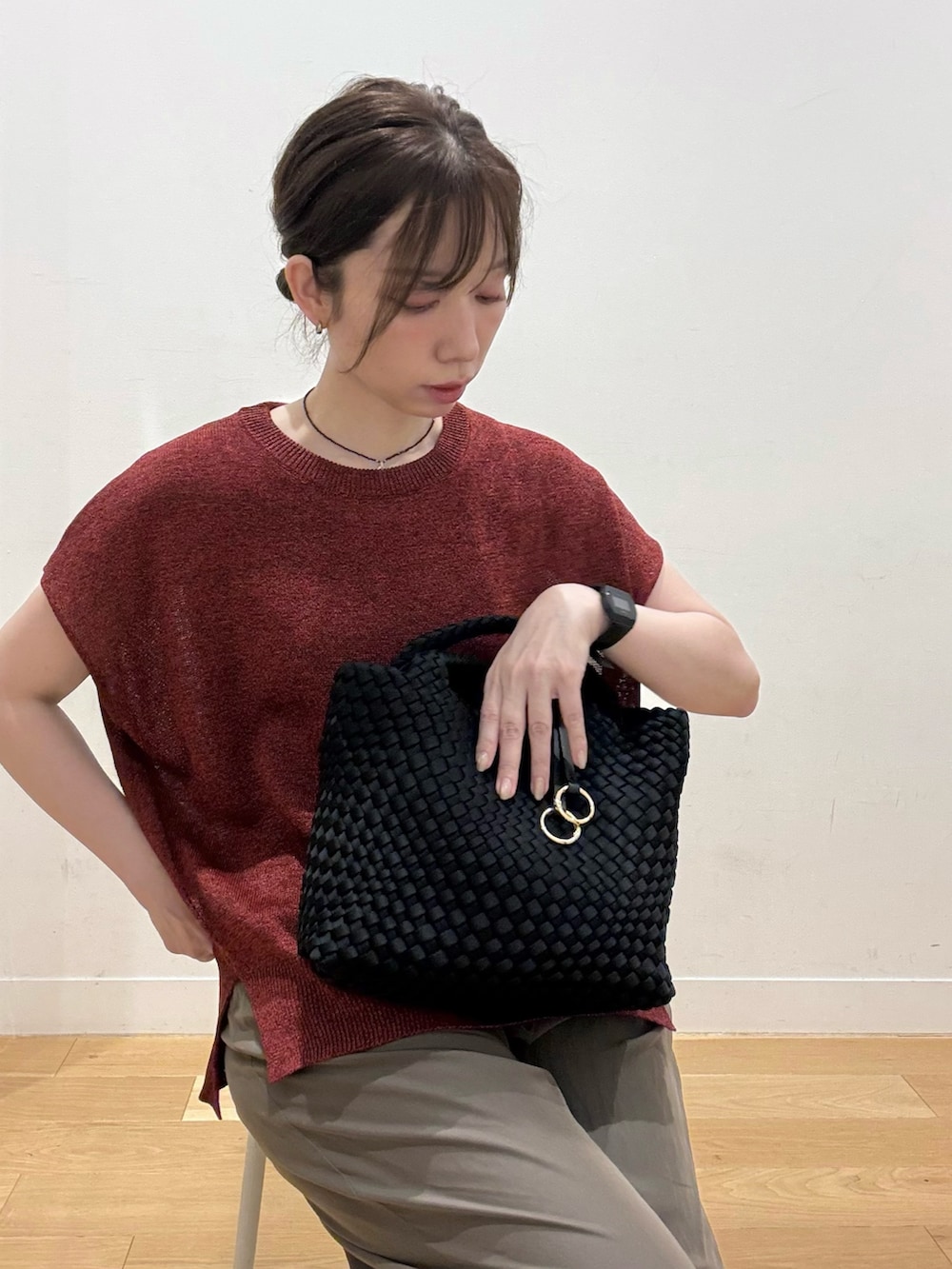 ブラック系のハンドバッグ、レッド系のその他トップス、ブラウン系のその他パンツを着用したレディースの夏コーディネートの3枚目の写真