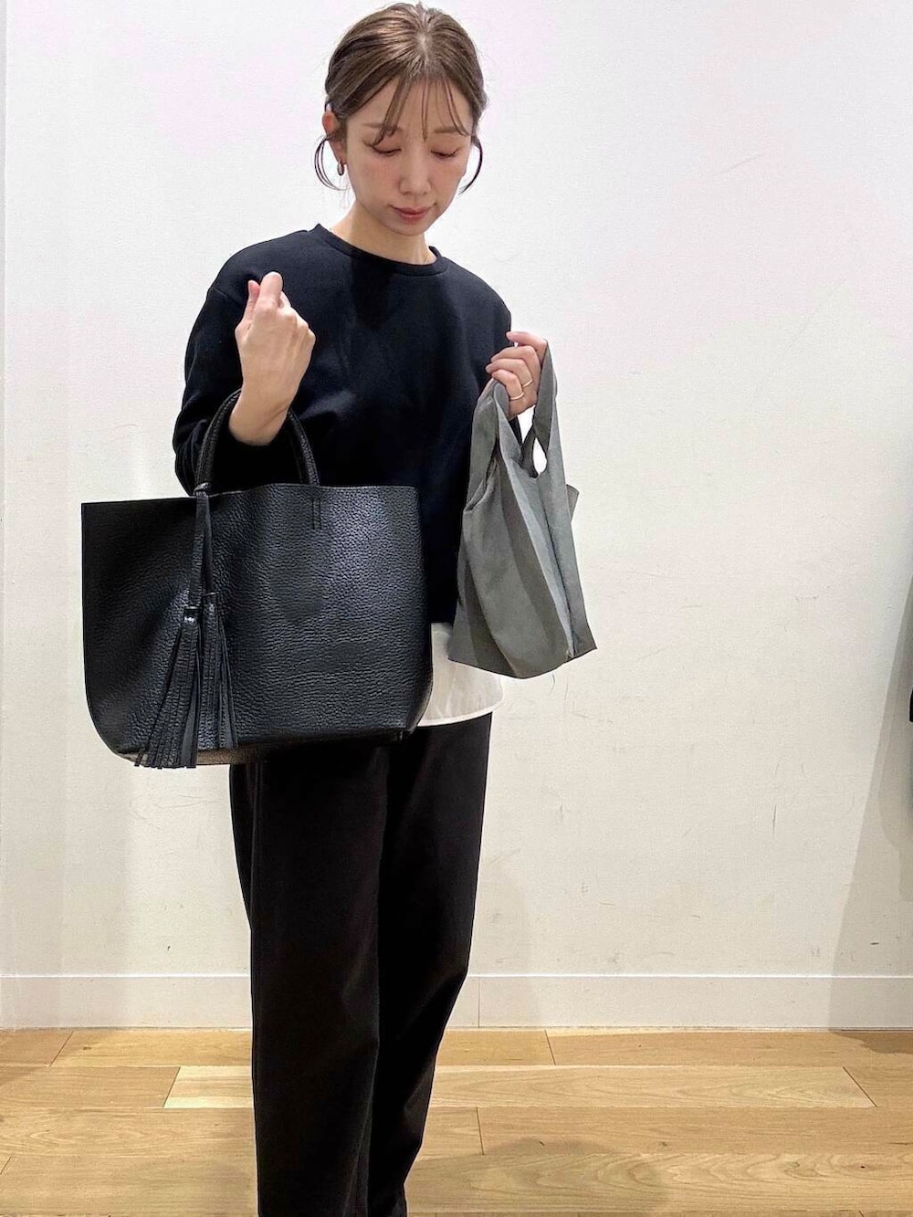 ブラック系のトートバッグ、ブラック系のパンプス、グレー系のエコバッグ/サブバッグを着用したレディースの冬コーディネートの9枚目の写真