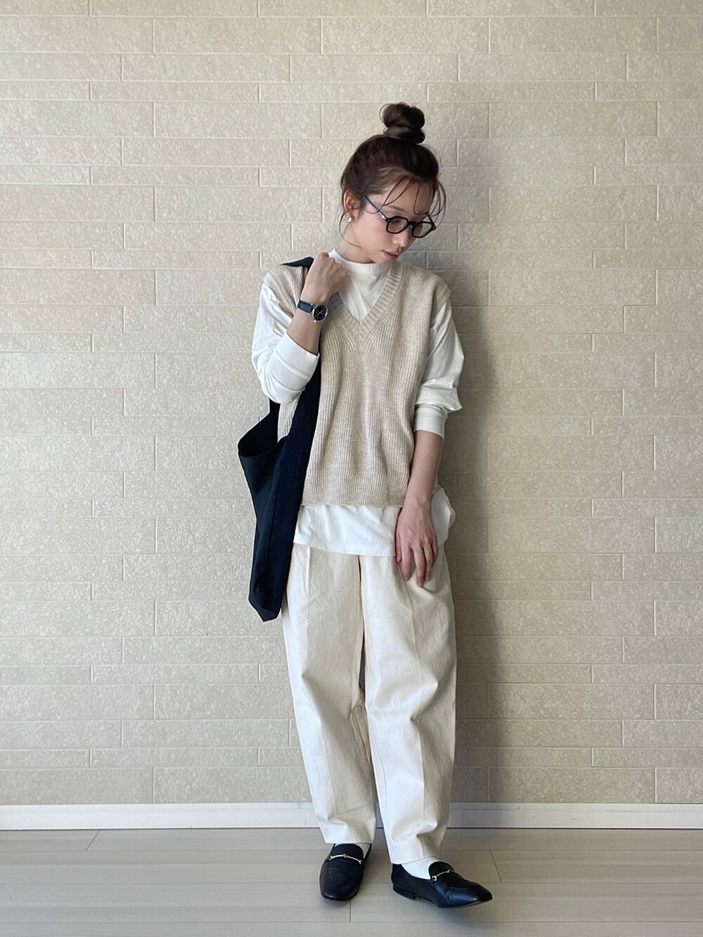 ホワイト系のその他パンツ、ブラック系のショルダーバッグ、ベージュ系のベストを着用したレディースの冬コーディネートの3枚目の写真