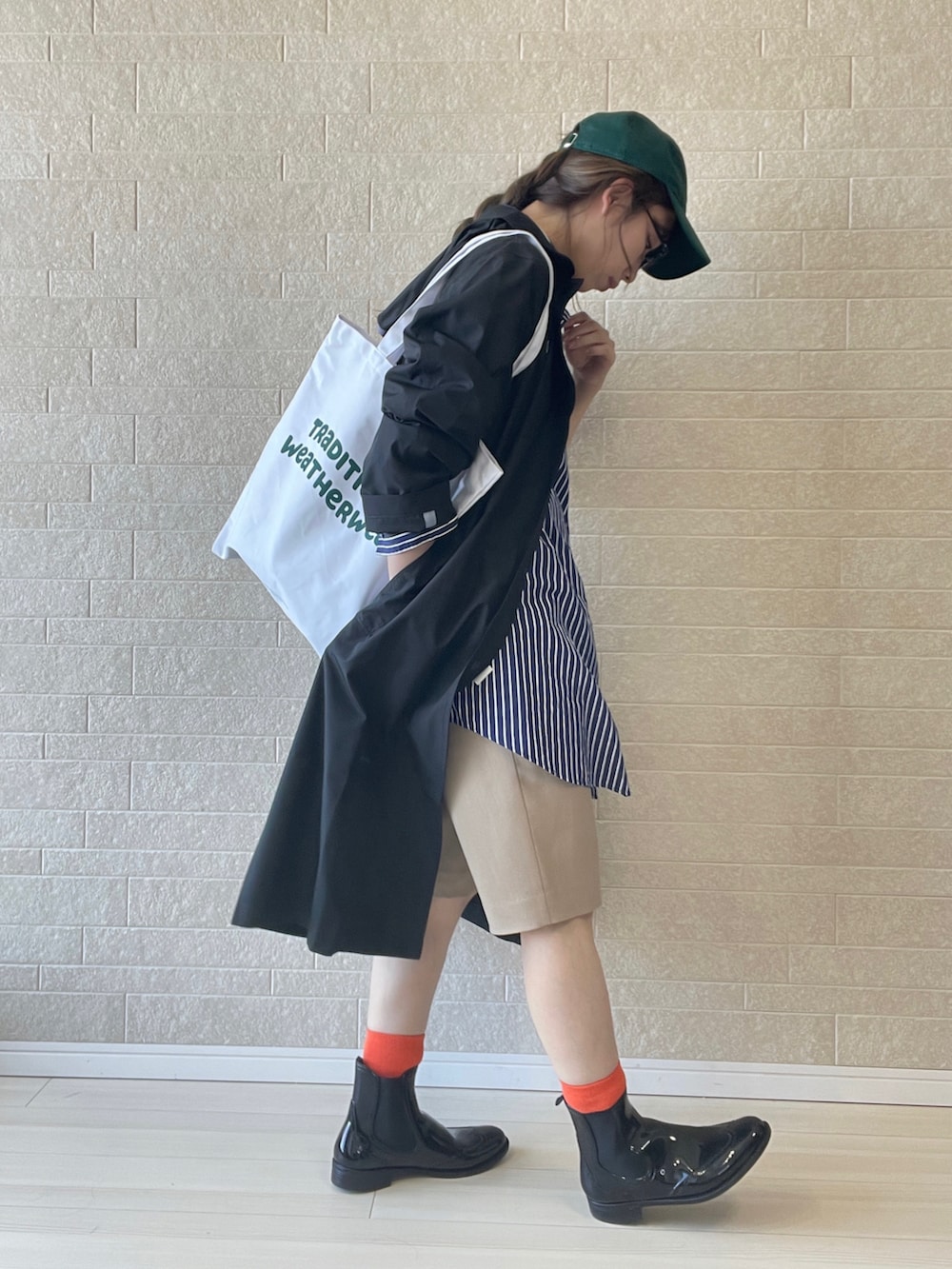 ホワイト系のトートバッグ、ブラック系のレインシューズ、ブルー系のシャツ/ブラウスを着用したレディースの春コーディネートの4枚目の写真