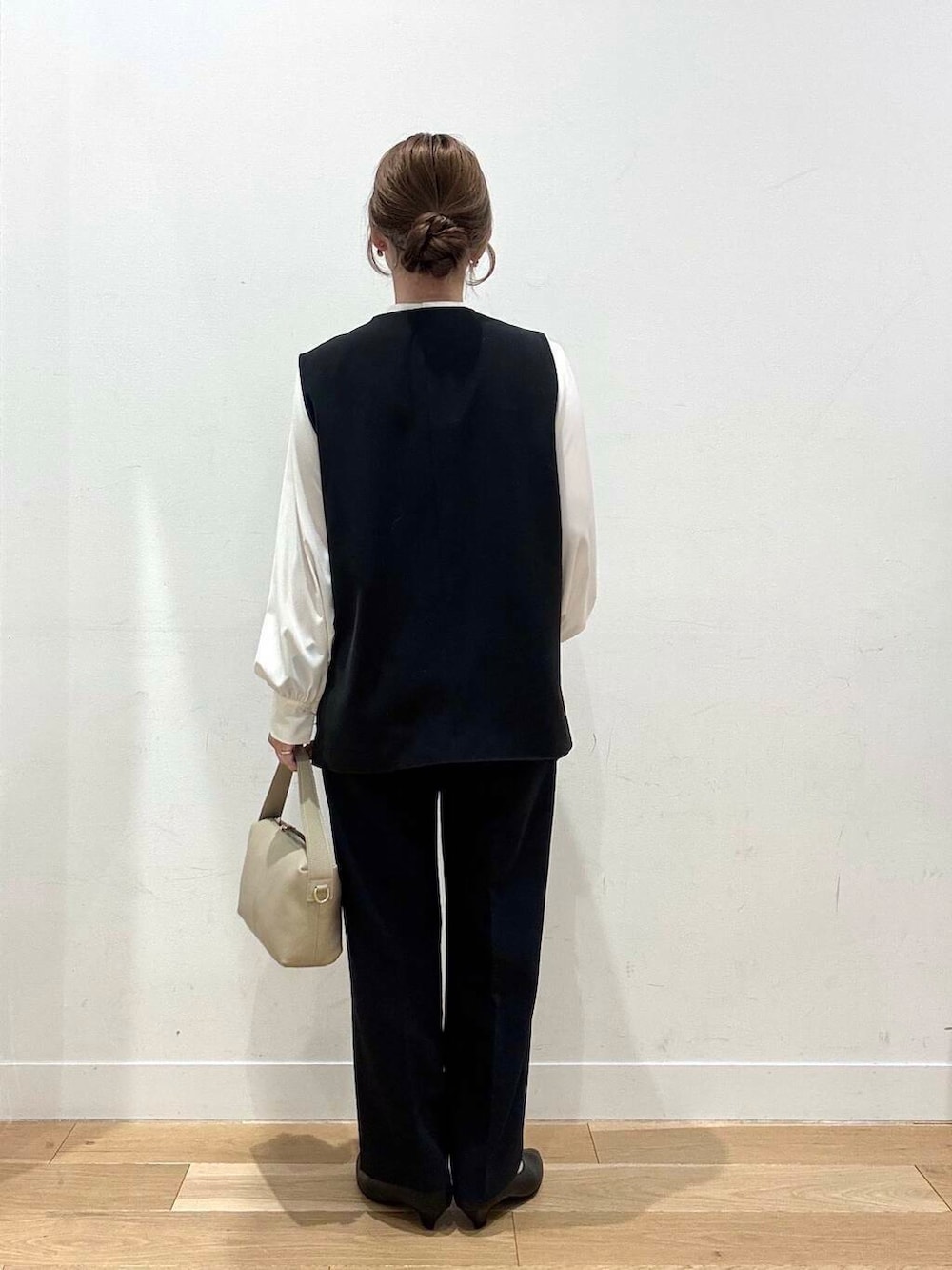 ホワイト系のショルダーバッグ、ブラック系のベスト、ホワイト系のシャツ/ブラウスを着用したレディースの冬コーディネートの6枚目の写真