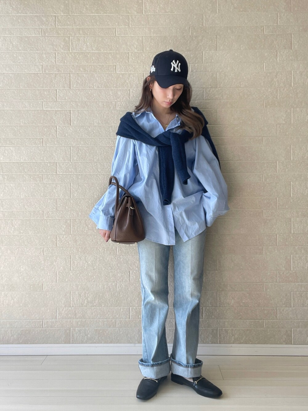 ブルー系のデニムパンツ、ブラック系のローファー、ブルー系のニット/セーターを着用したレディースの秋コーディネートの2枚目の写真