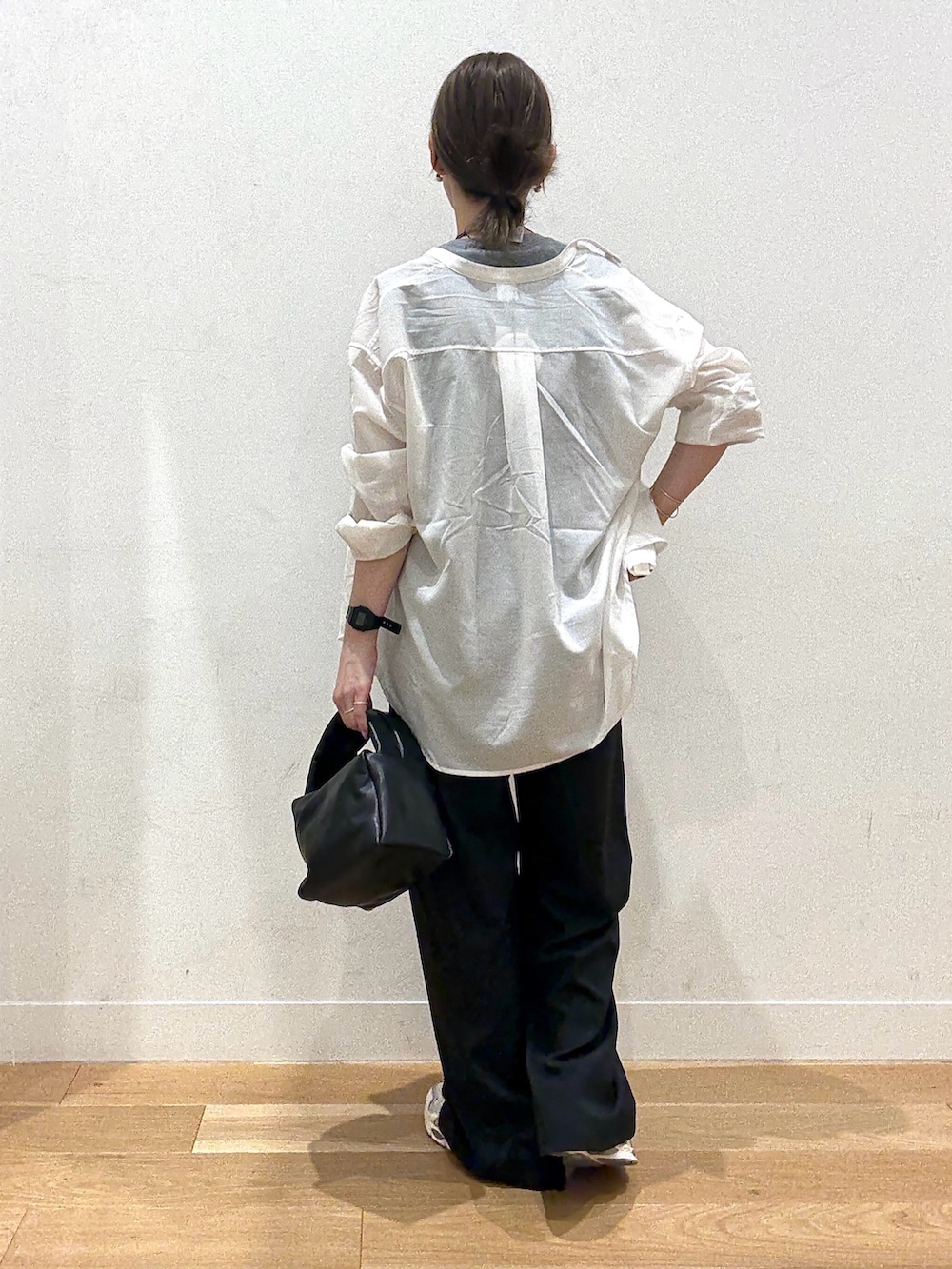 ブラック系のハンドバッグ、ブラック系のワンピース、グレー系のTシャツ/カットソーを着用したレディースの秋コーディネートの3枚目の写真