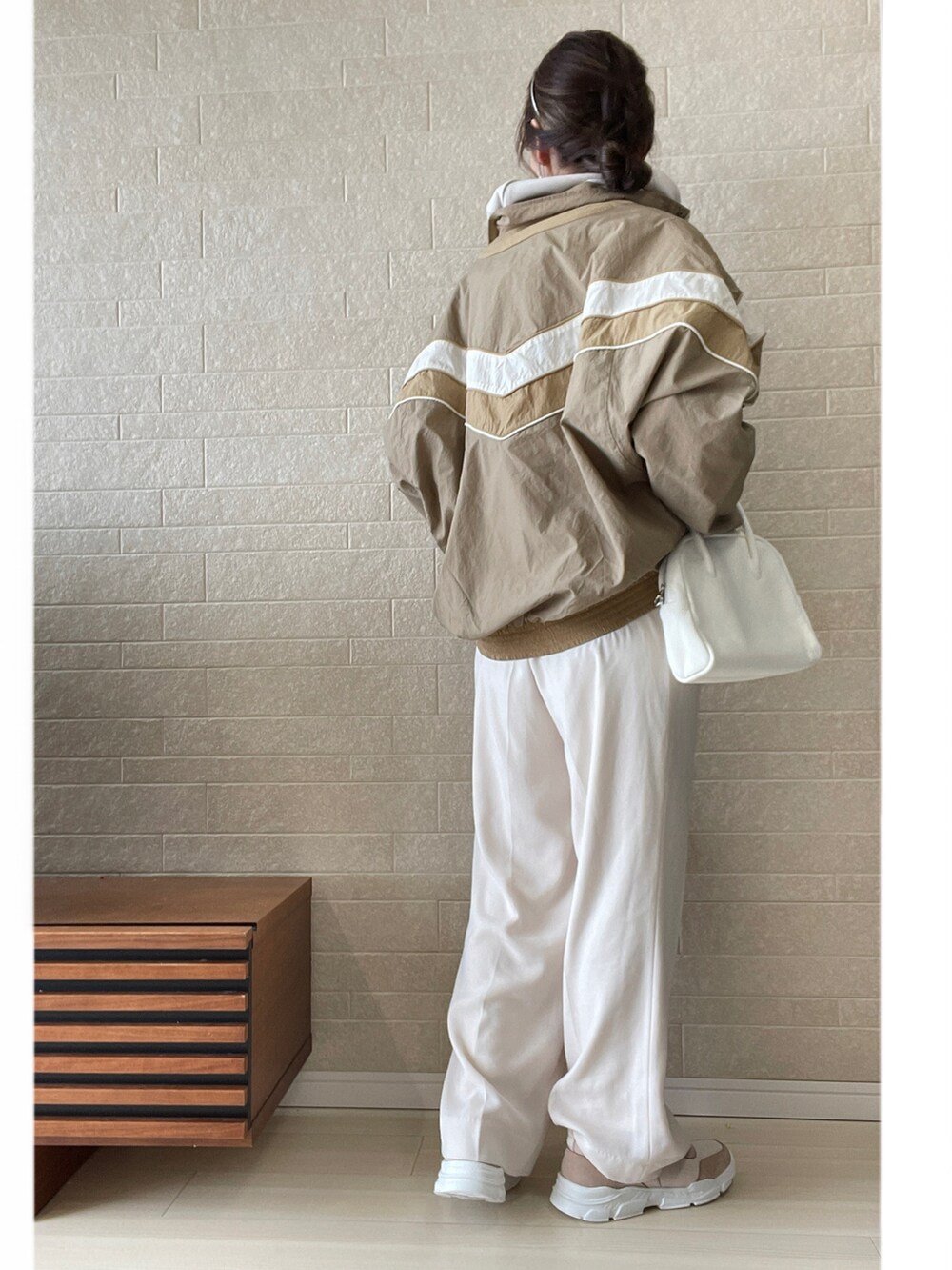 ピンク系のスニーカー、ホワイト系のその他パンツ、ホワイト系のボストンバッグを着用したレディースの春コーディネートの4枚目の写真