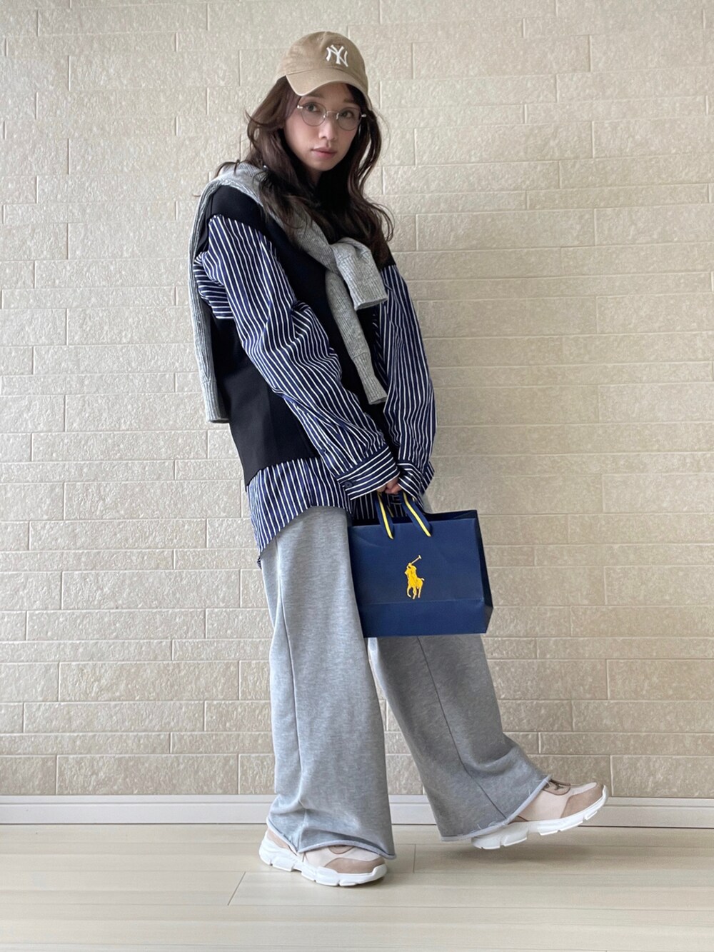 ピンク系のスニーカー、ブルー系のシャツ/ブラウス、ブラック系のベストを着用したレディースの冬コーディネートの3枚目の写真