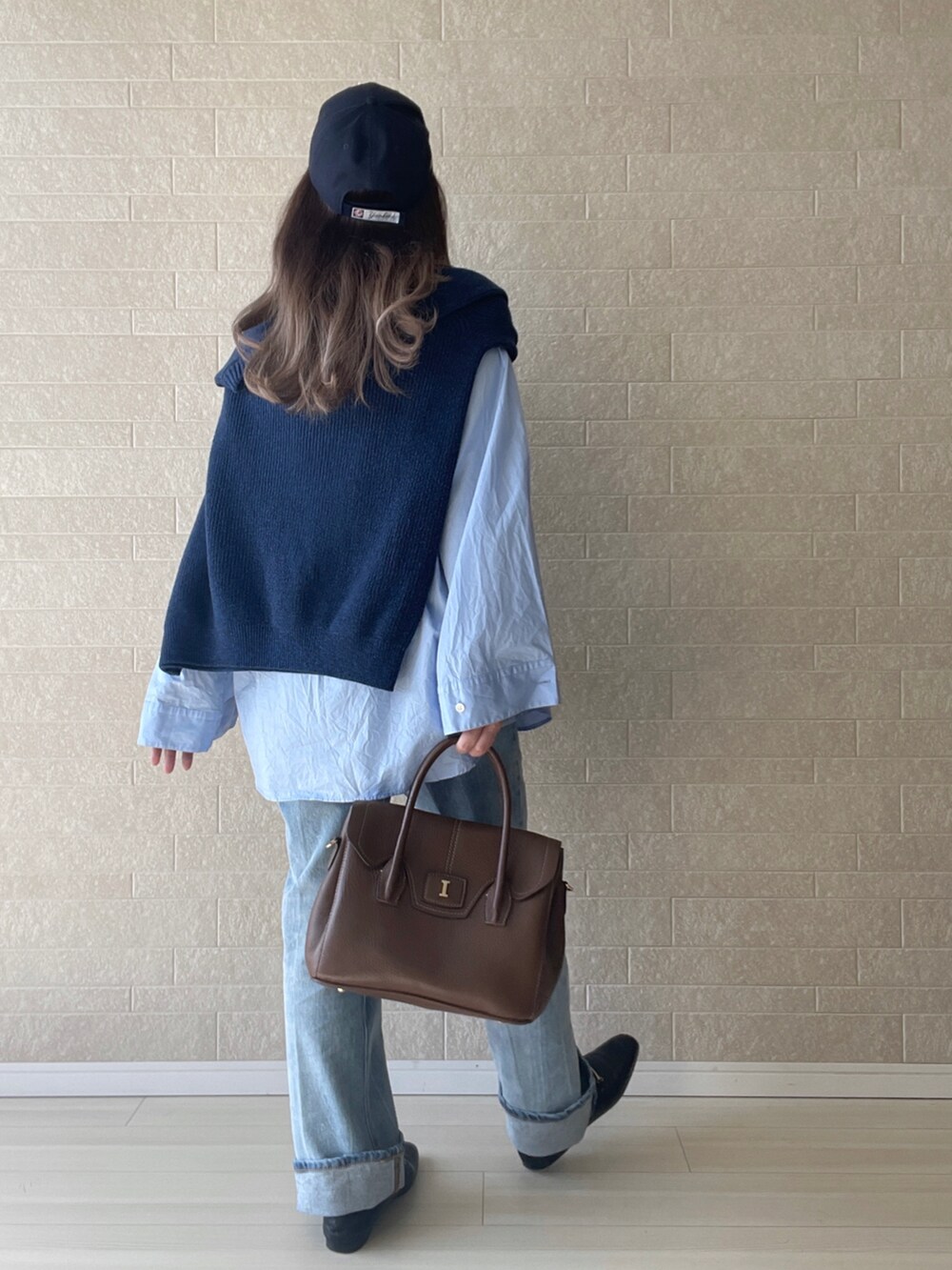 ブルー系のデニムパンツ、ブラック系のローファー、ブルー系のニット/セーターを着用したレディースの秋コーディネートの4枚目の写真