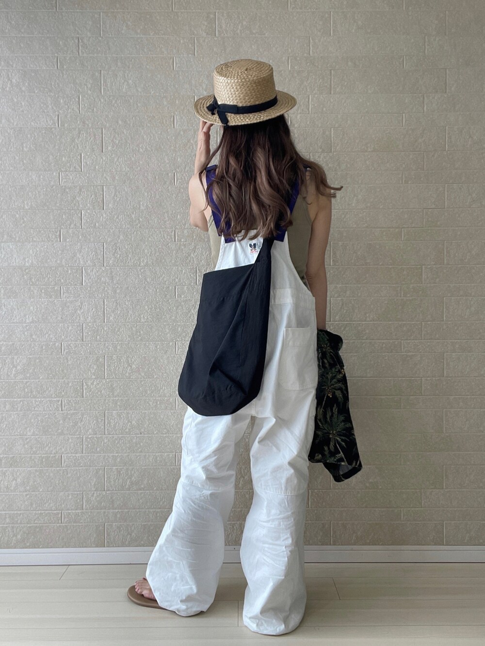 ホワイト系のサロペット/オーバーオール、ブラウン系のサンダル、ブラック系のショルダーバッグを着用したレディースの夏コーディネートの2枚目の写真
