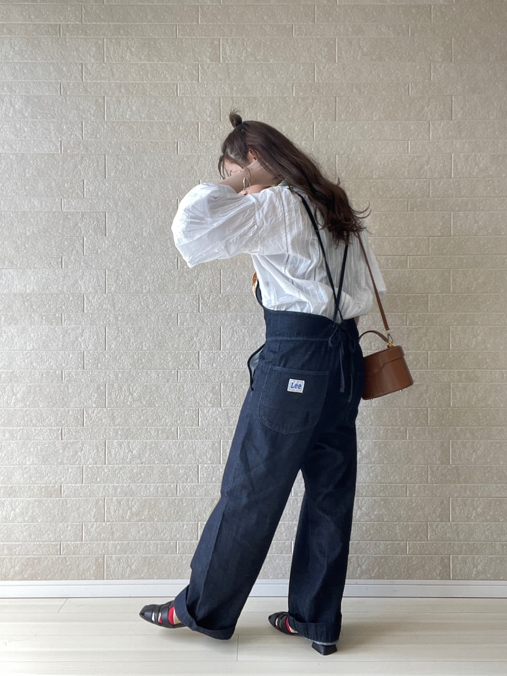 ブルー系のサロペット/オーバーオール、ブラック系のパンプス、イエロー系のハンドバッグを着用したレディースの春コーディネートの4枚目の写真