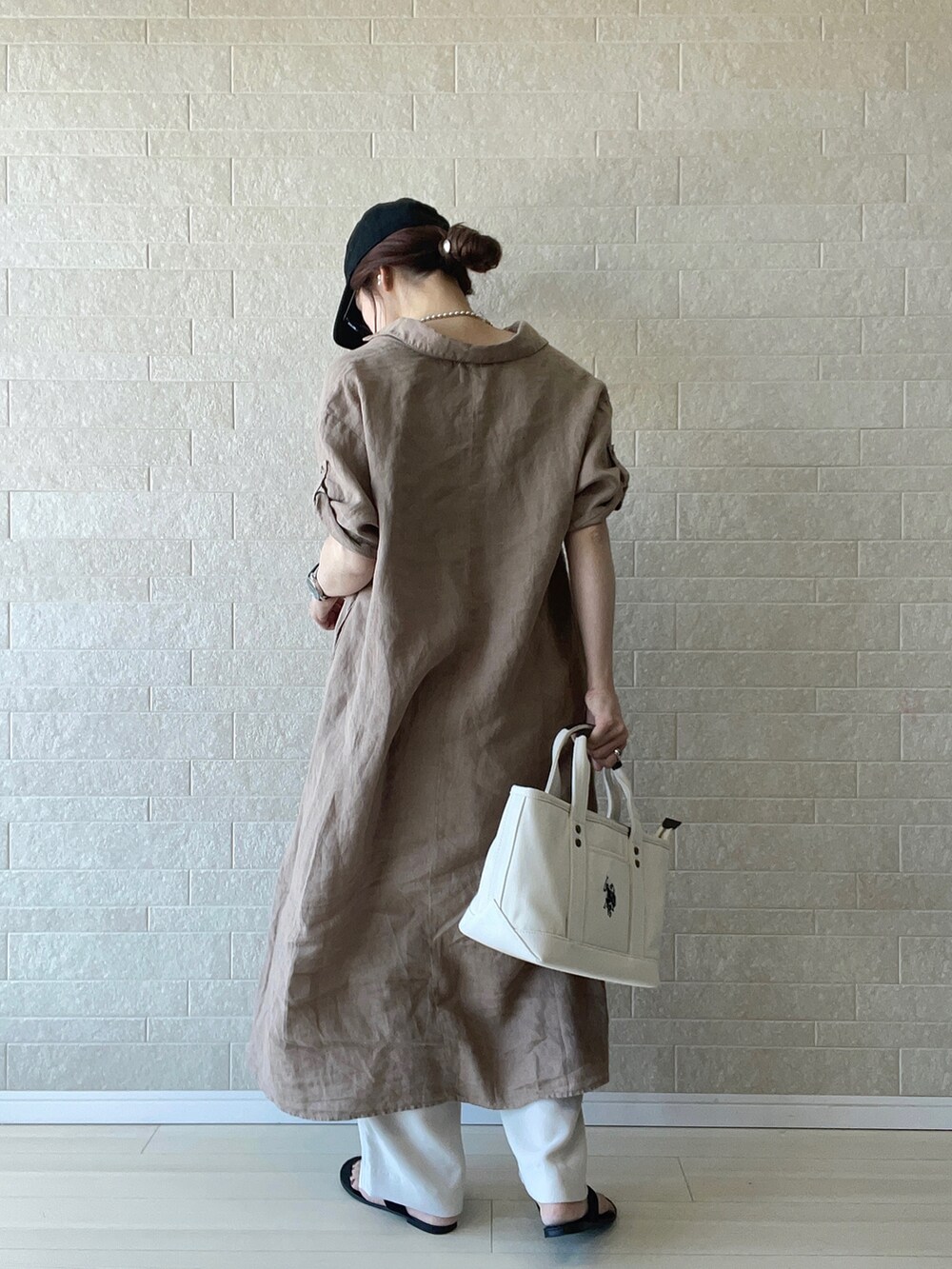 ホワイト系のトートバッグ、ブラウン系のワンピース、ホワイト系のその他パンツを着用したレディースの春コーディネートの3枚目の写真