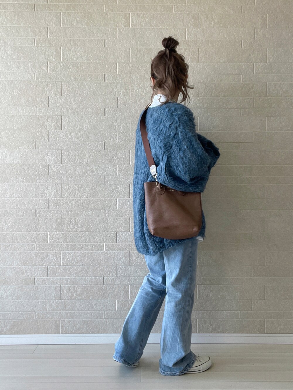 ブルー系のデニムパンツ、ホワイト系のシャツ/ブラウス、ブルー系のニット/セーターを着用したレディースの秋コーディネートの3枚目の写真