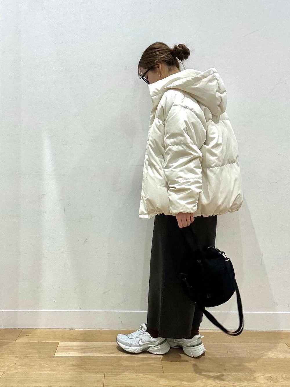 ホワイト系のスニーカー、グレー系のスカート、ホワイト系のダウンジャケット/コートを着用したレディースの冬コーディネートの4枚目の写真