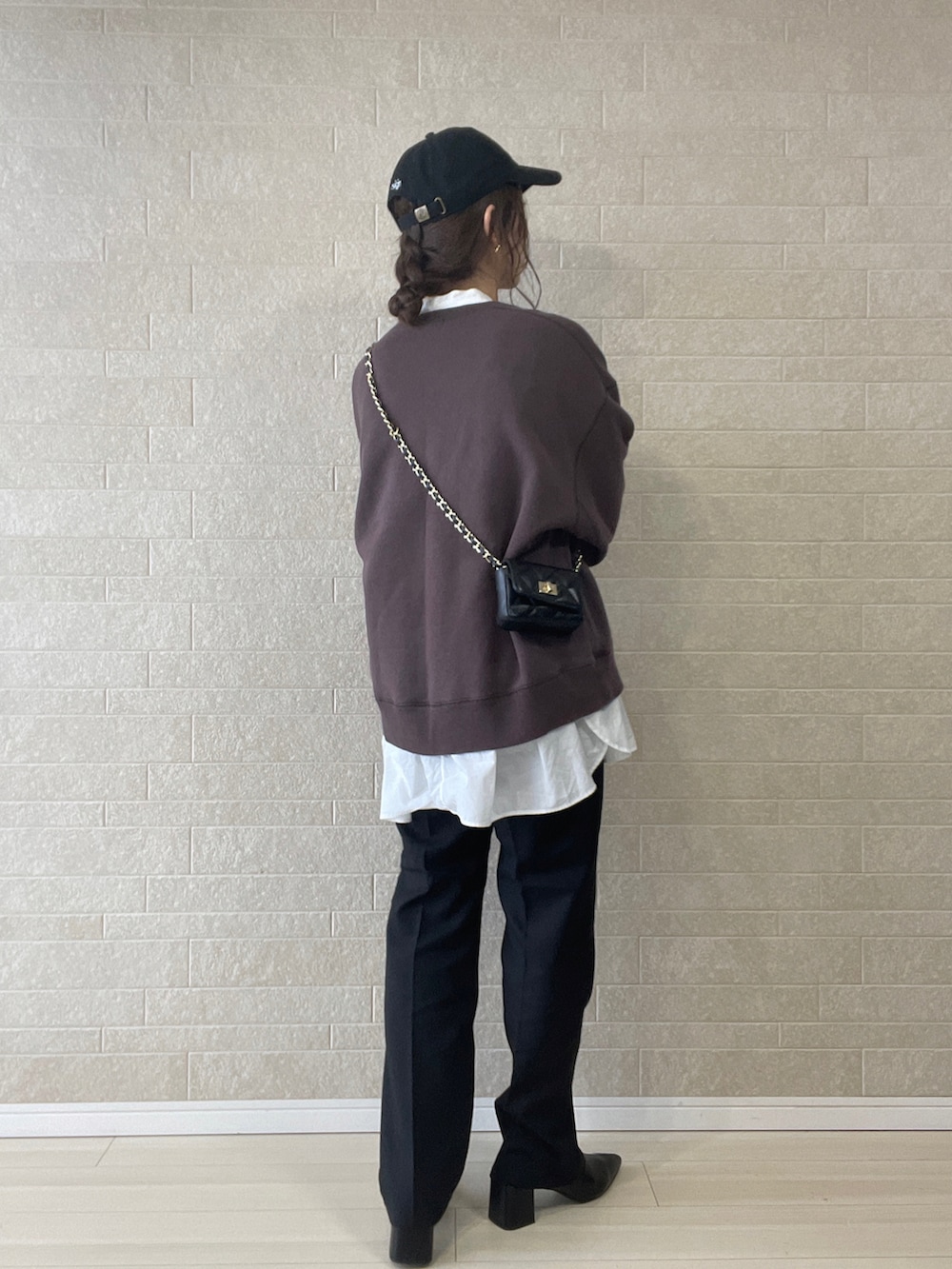 ブラック系のスラックス、ブラック系のブーツ、ブラウン系のスウェットを着用したレディースの秋コーディネートの4枚目の写真