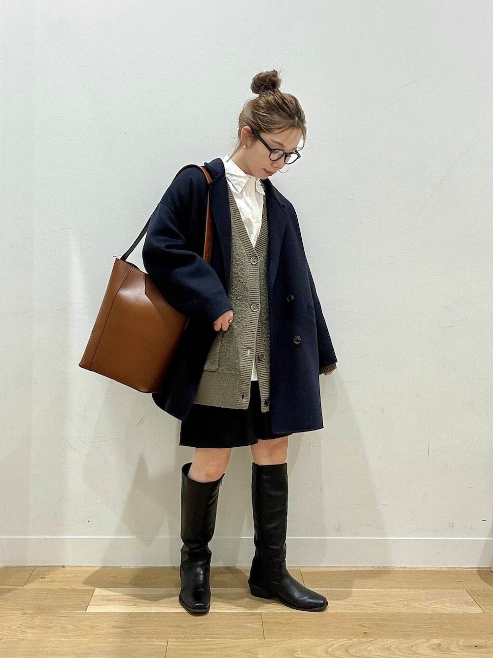 ブルー系のその他アウター、ホワイト系のシャツ/ブラウス、ブラウン系のトートバッグを着用したレディースの冬コーディネートの2枚目の写真