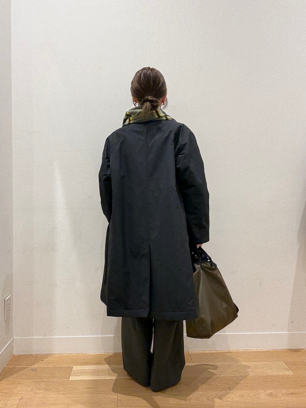 レッド系のニット/セーター、ブラック系のステンカラーコート、グリーン系のショルダーバッグを着用したレディースの秋コーディネートの5枚目の写真