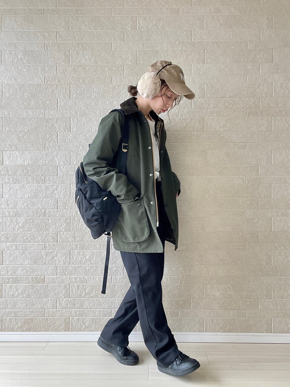 ブラック系のスラックス、グリーン系のブルゾン、ブラック系のスニーカーを着用したレディースの秋コーディネートの2枚目の写真