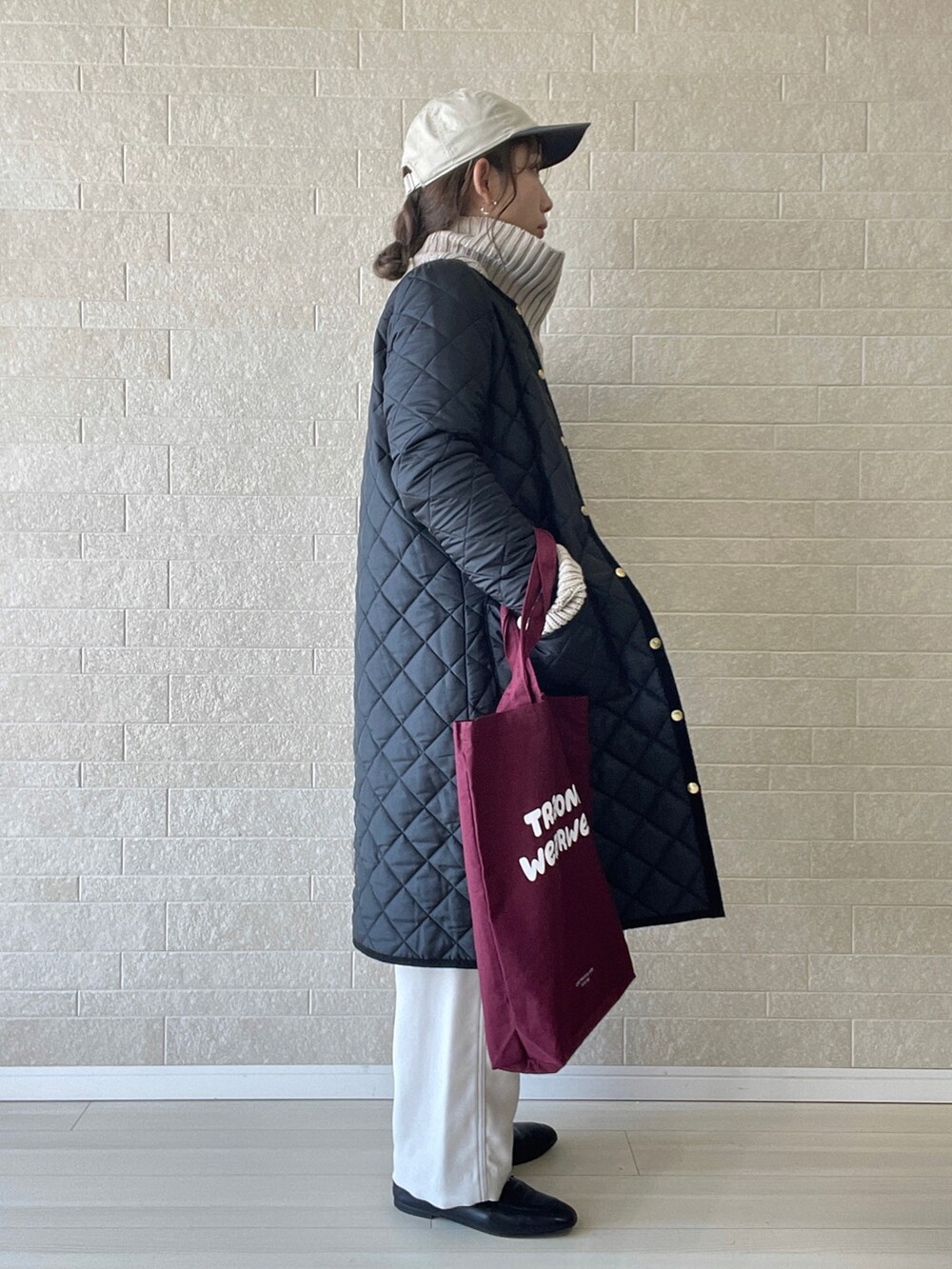 ブラック系のその他アウター、レッド系のトートバッグ、ブラウン系のニット/セーターを着用したレディースの秋コーディネートの3枚目の写真