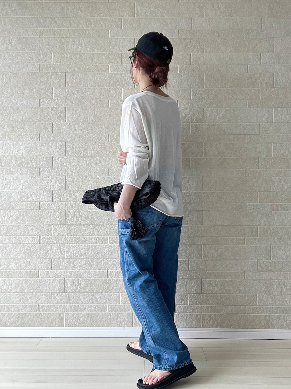 ブルー系のデニムパンツ、ホワイト系のTシャツ/カットソー、ブラック系のサンダルを着用したレディースの春コーディネートの3枚目の写真