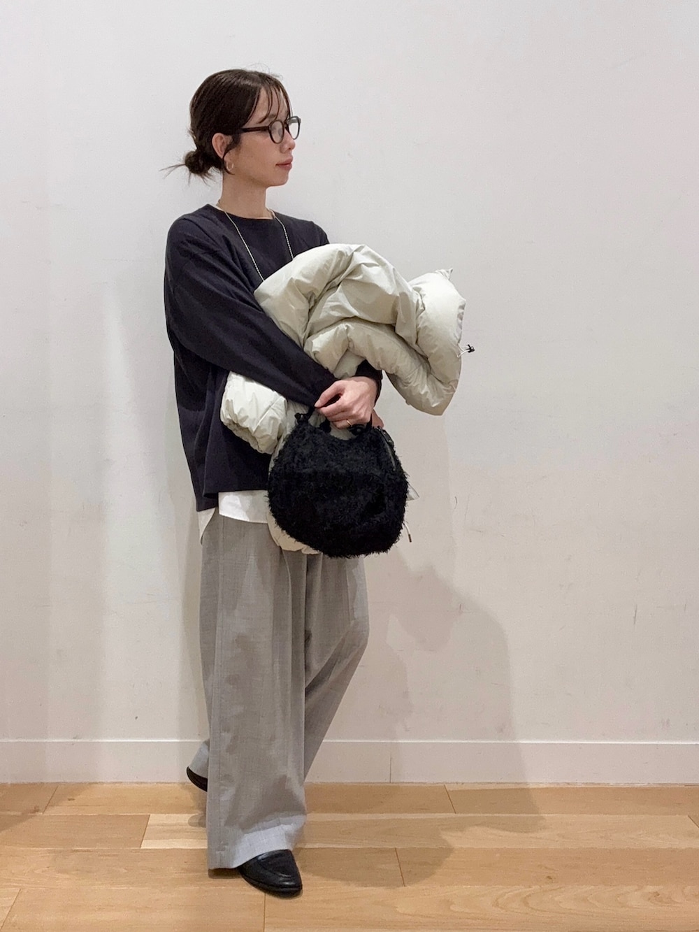 グレー系のニット/セーター、ホワイト系のダウンジャケット/コート、ブラック系のハンドバッグを着用したレディースの秋コーディネートの7枚目の写真