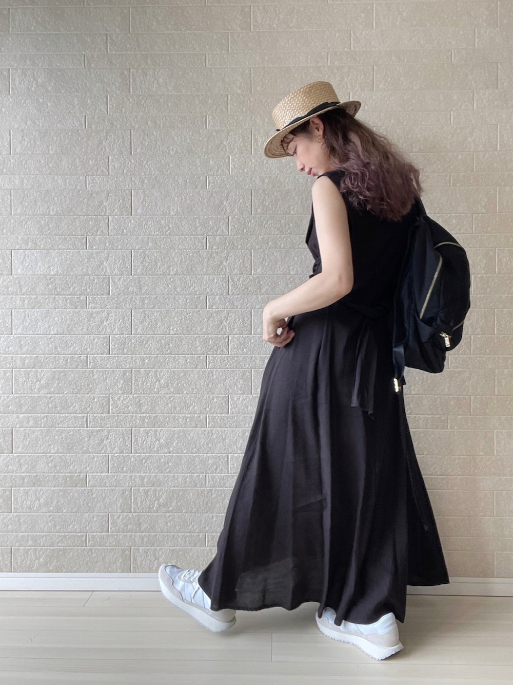 ブラック系のワンピース、ベージュ系のスニーカー、ブラック系のバックパック/リュックを着用したレディースの夏コーディネートの2枚目の写真