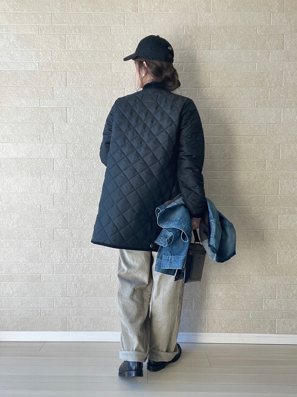 ブラック系のその他アウター、ブラック系のニット/セーター、ベージュ系のパンツを着用したレディースの冬コーディネートの4枚目の写真