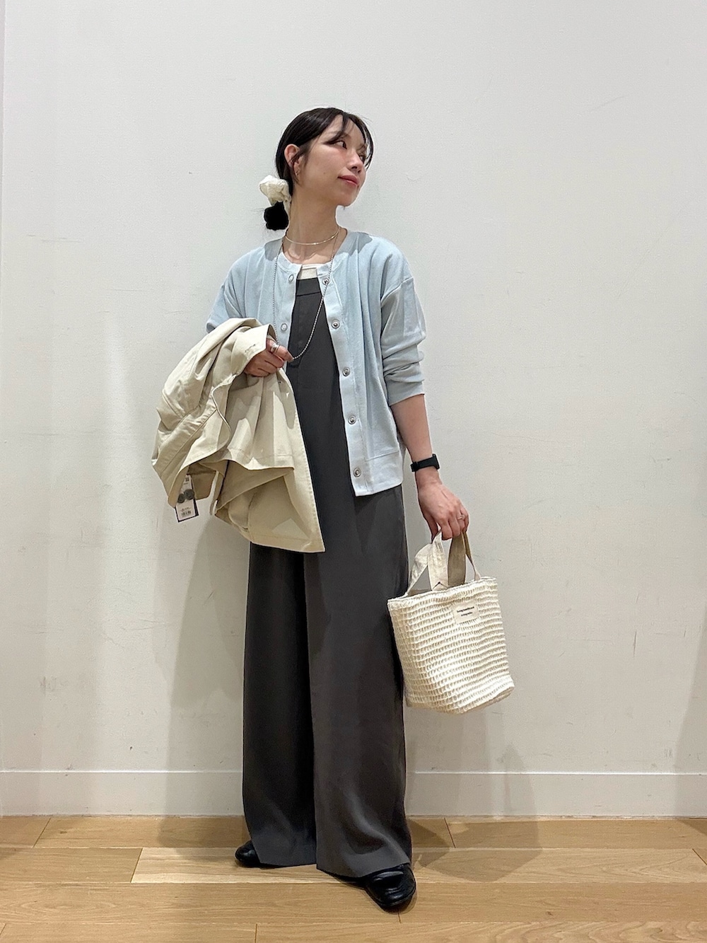 ホワイト系のトートバッグ、ブルー系のカーディガン/ボレロ、ホワイト系のタンクトップを着用したレディースの春コーディネートの3枚目の写真
