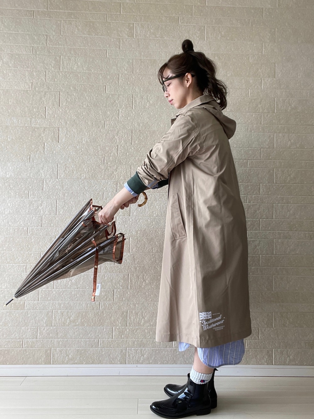 ブラック系のレインシューズ、ブラック系のショルダーバッグ、ブルー系のシャツワンピースを着用したレディースの春コーディネートの5枚目の写真